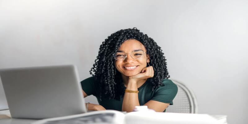 A person with curly hair and a computer AI-generated content may be incorrect.