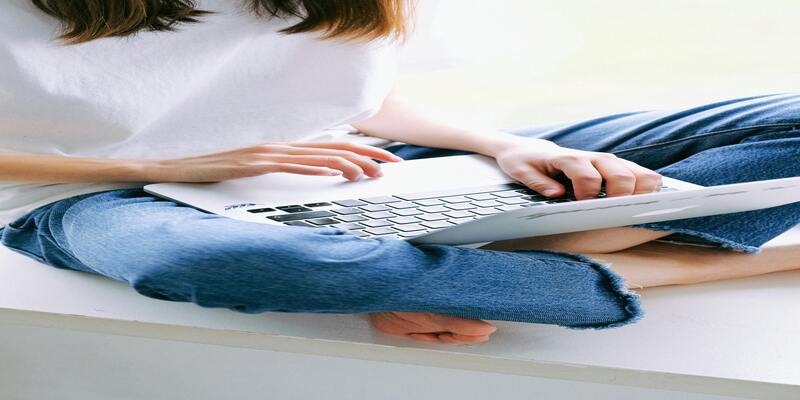 A person sitting on a white surface using a computer AI-generated content may be incorrect.