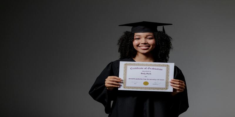 A person in a graduation gown holding a certificate AI-generated content may be incorrect.