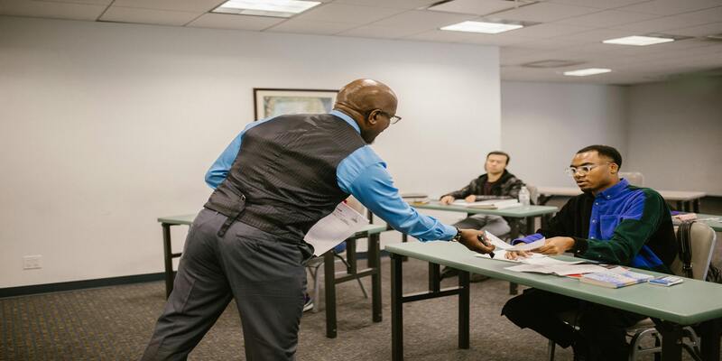 A person in a blue shirt and black vest AI-generated content may be incorrect.