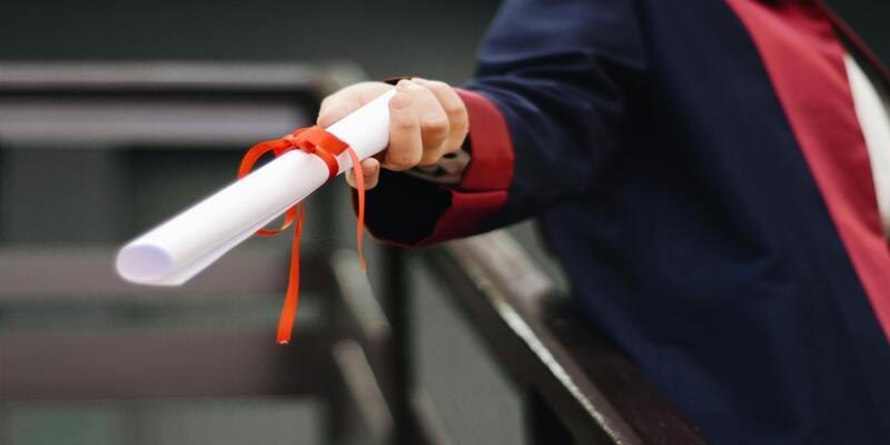 A person holding a diploma AI-generated content may be incorrect.